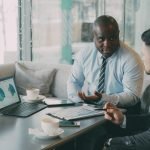 Two business professionals engaged in discussion over laptops and documents. — A Simple 30-Day Notice Prevents Misunderstandi
