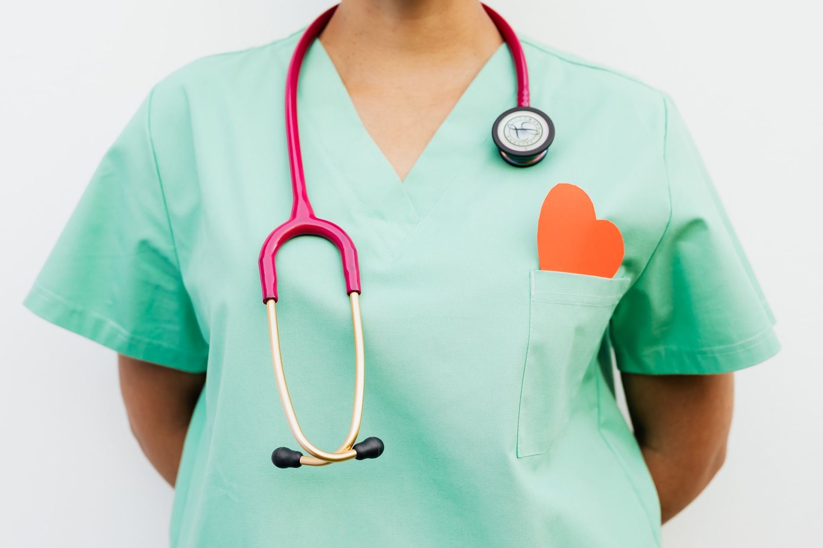 Close-up of a medical professional with a stethoscope and a paper heart cutout on a green uniform pocket. — Buy Trenbolone On