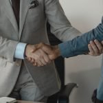 Image of a professional handshake between two businessmen in an office setting. — Customize Your Nicotine Levels with IVG E-L