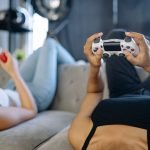 Two women relaxing and playing video games on a couch in a cozy living room. — Eat and Run Crackdown Team Screens Sites to Pr