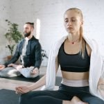 Two people meditating on yoga mats within a calm and bright studio setting. — Embracing the Divine: How Angelic Intercession