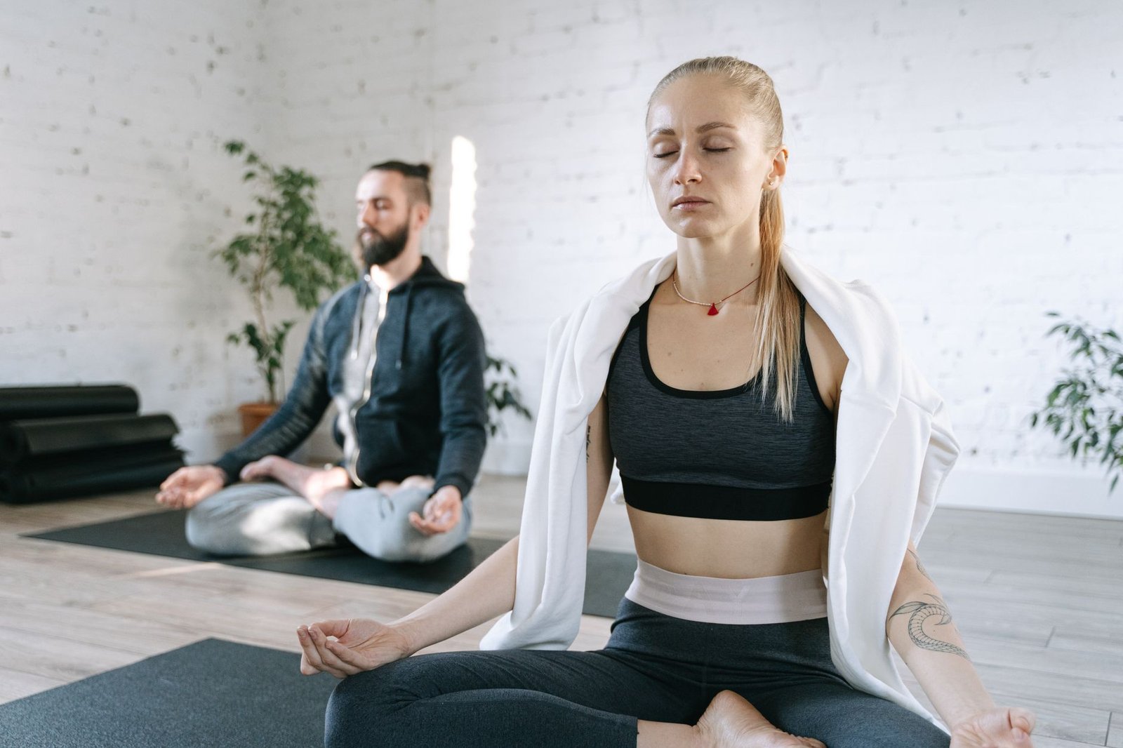 Two people meditating on yoga mats within a calm and bright studio setting. — Embracing the Divine: How Angelic Intercession