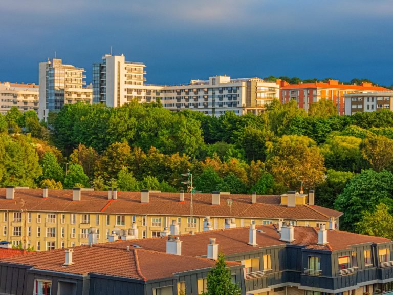 A scenic urban landscape featuring modern buildings and lush greenery at sunset. — Gain Clarity on Tenant Obligations with an