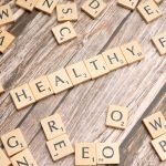 Wooden letter tiles arranged on a wooden surface spelling out 'healthy', symbolizing wellness. — How a Master of Physician As
