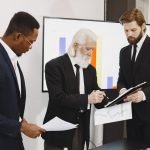 Three businessmen in suits reviewing reports and graphs during an office meeting. — Make the Most of your Bankroll: Strategie