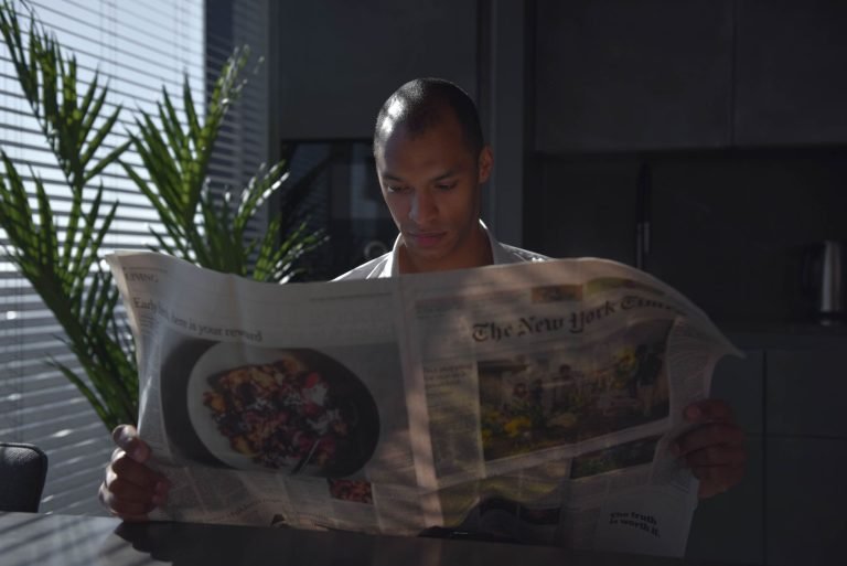 Businessman focused on reading newspaper in a sunny indoor office setting. — Risk Management Mastery: Safeguarding Your Inves
