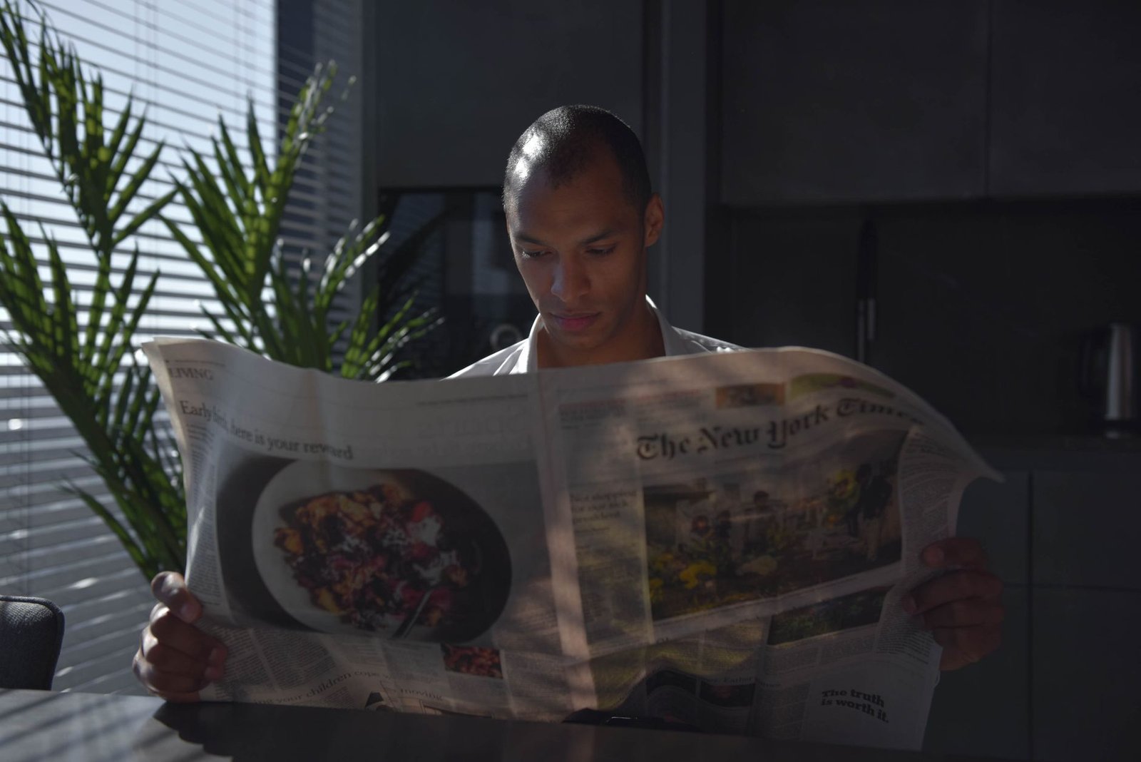 Businessman focused on reading newspaper in a sunny indoor office setting. — Risk Management Mastery: Safeguarding Your Inves