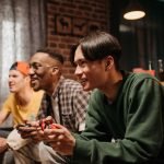 Diverse group of young adults enjoying video games together indoors, creating a fun and social atmosphere. — Safe Toto Platfo