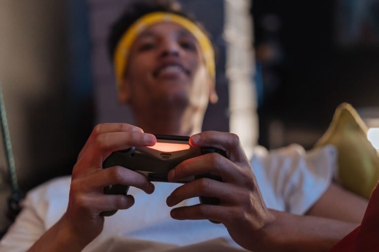 A relaxed gaming session with a close-up view of a man holding a game controller indoors. — The Difference Between Mini-Bacca