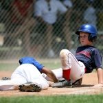 Young baseball players in action during an intense game at a sunlit field. — UnionRayo: Uniting the Vallecas Community Throug